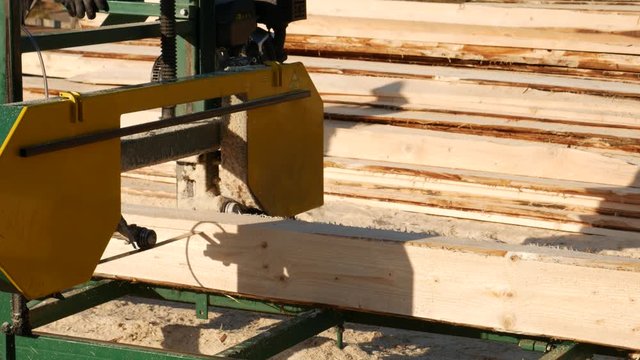 A close up view of an sawmill machine, processing a log of wood at a wood processing mill. .