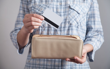 Girl holds and insert credit card in her wallet.