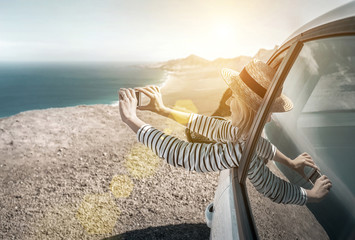 Happiness young woman sitting in white car and shoot with her ph