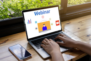 Person using a laptop computer for online training webinars. E-learning browsing connection and cloud online technology webcast concept. Laptop mockup with clipping path on screen.