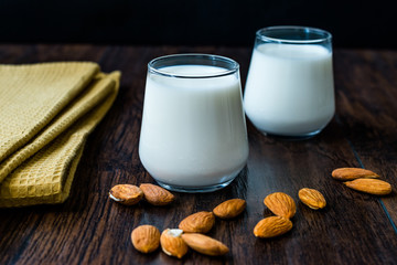 Almond Milk in Glass Cups with Almonds and Fabric Cloth.