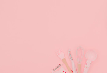 Various pink kitchen utensils on abstract pink background. Greater, whisk and iron cooking form. Top horizontal view copyspace love cookong concept