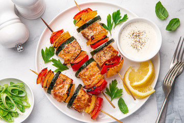 Grilled salmon and vegetables skewers on white plate - Powered by Adobe