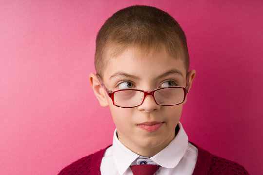 Closeup Portrait Kid With Glasses Avoiding Eye Contact Looking Side Got In Unpleasant Awkward Situation Feels Embarrassed. Red Background