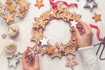 Close up of female hands and Christmas   Gingerbread cookies wreath