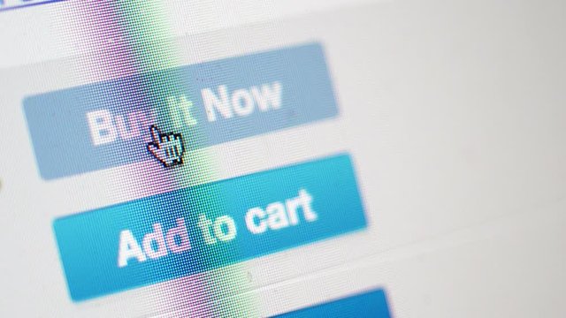 Closeup of mouse cursors click at buy it now button .