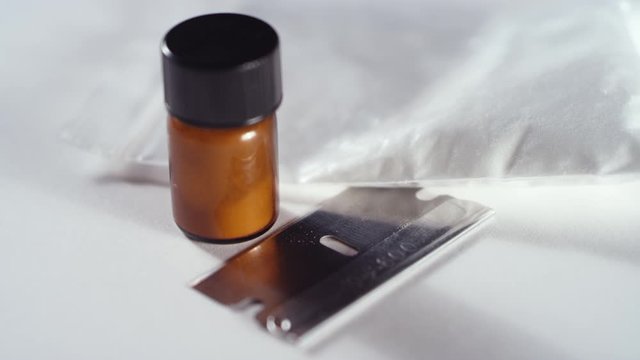 Close-up cocaine drug paraphernalia spinning on a white background