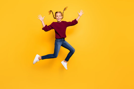 Full length body size photo of cheerful positive excited gitl in jeans denim burgundy sweater jumping up footwear isolated vivid color background