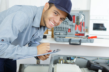 smiling technician repairing an hot-water heater