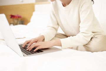 Fototapeta premium asian woman using laptop on bed