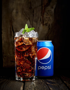 POLTAVA, UKRAINE, FEBRUARY 15, 2016  Can and glass of Pepsi-Cola with ice on wooden background. Pepsi is a carbonated soft drink sold in stores, restaurants, and vending machines throughout the world.