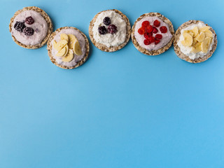 Sweets made of crispy bread and fruit on a blue background. There is room for text at the bottom