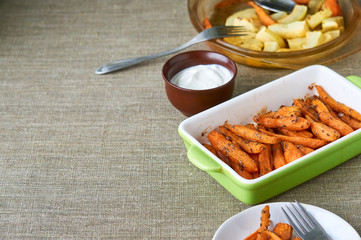 Baked carrots on a brown textile background