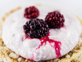 The juice of juicy BlackBerry berries flows over the curd dessert on a white background