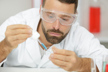 concentrated male biologist holding a test tube in a lab
