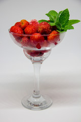 frozen strawberries with mint leaves in a glass on a white background