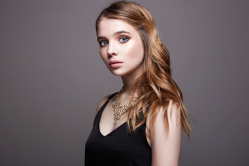 Fototapeta premium Beautiful sensual blond Girl in black dress and jewelry