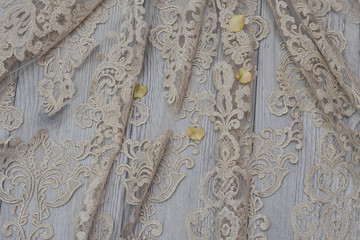 White wooden background with white spring flowers roses and lace ribbon. Happy womans day. The texture of lace on wooden background.