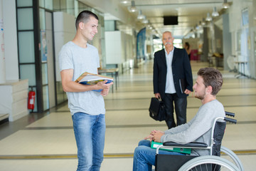 Obraz premium thoughtful disabled boy in wheelchair in corridor at school
