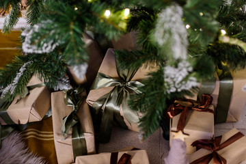 Fototapeta na wymiar Beautiful Christmas gift boxes on floor near fir tree