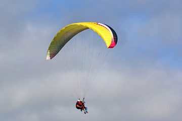 Tandem Paraglider flying wing in a cloudy sky