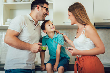 Modern family using a digital tablet while having breakfast in the kitchen