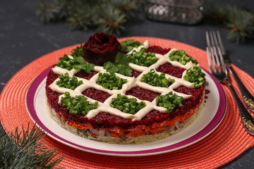Traditional Russian holiday salad Herring under a fur coat on a Christmas background, horizontal orientation
