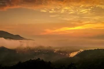Mountain view misty morning above Kok river and Tha Ton city in valley around with sea of mist with cloudy sky background, sunrise at Wat Tha Ton, Fang, Chiang Mai, northern of Thailand.
