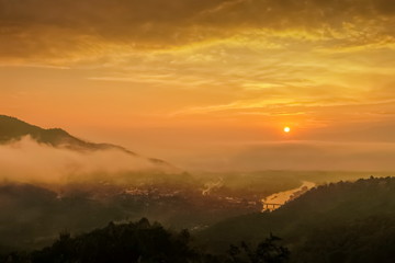 Mountain view misty morning above Kok river and Tha Ton city in valley around with sea of mist with cloudy sky background, sunrise at Wat Tha Ton, Fang, Chiang Mai, northern of Thailand.