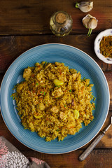 Pilaf with mint in a blue plate on a wooden background. Copyspace 