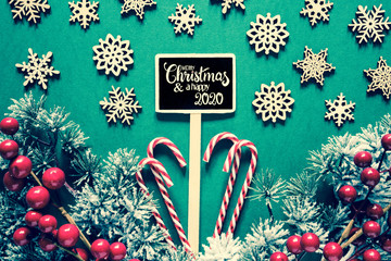 Sign With English Text Merry Christmas And Happy 2020. Green Retro Background With Christmas Decoration And Fir Branch