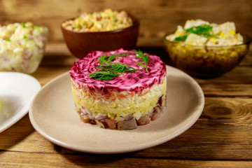 Set of festive mayonnaise salads on wooden table