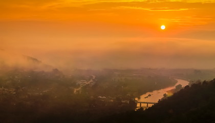 Mountain view panorama misty morning above Kok river and Tha Ton city in valley around with sea of mist and yellow sky background, sunrise at Wat Tha Ton, Fang, Chiang Mai, northern of Thailand.