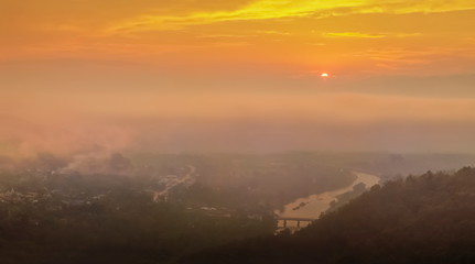 Mountain view panorama misty morning above Kok river and Tha Ton city in valley around with sea of mist and yellow sky background, sunrise at Wat Tha Ton, Fang, Chiang Mai, northern of Thailand.