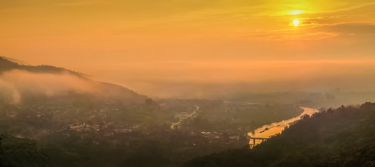Mountain view panorama misty morning above Kok river and Tha Ton city in valley around with sea of mist and yellow sky background, sunrise at Wat Tha Ton, Fang, Chiang Mai, northern of Thailand.
