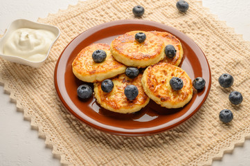 Homemade cheesecakes on a plate with berries and syrup close-up. Healthy food
