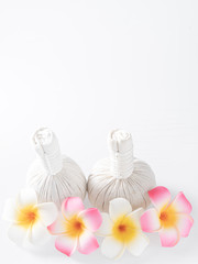 Herbal massage balls and yellow flowers isolated on white. Spa and massage concept.