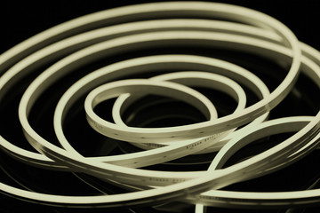 Warm white flexible led tape neon flex on black background.