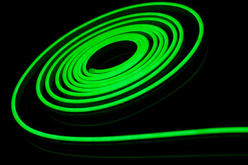 Green flexible led tape neon flex on black background.