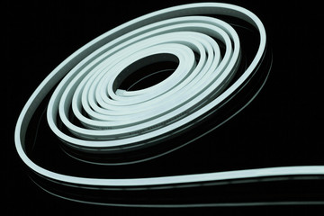 Cold white flexible led tape neon flex on black background.