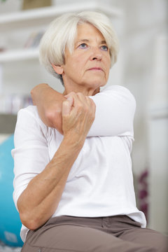 an elderly woman stretching arm