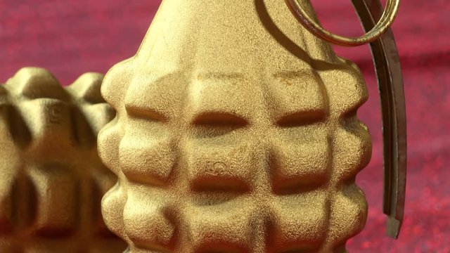 MK2 hand grenades. Two golden pineapple grenades on the red velvet cloth.