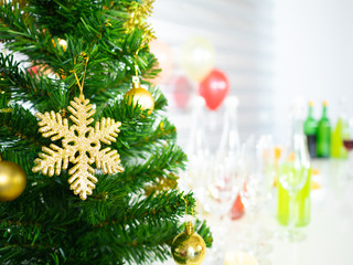 Golden snow flake and ornament decorated on green xmas pine tree with white party background scene included colorful balloon and glasses of champagne and wine drink beverage on Merry Christmas holiday