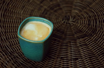 A blue cup of coffee without handle. Espresso closeup. Outdoor photography. Magical morning. Coffee with milk and foam. 100% Arabica. romantic breakfast