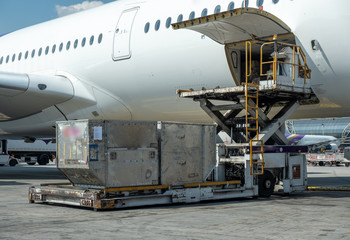 Air cargo logistic containers are loading to an airplane.