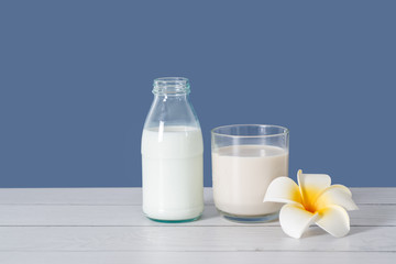Obraz na płótnie Canvas Milk in glass and bottle with blue background.