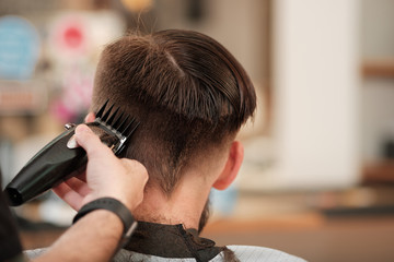 client haircuts at the hairdresser stylist. man cuts hair in a barbershop. 