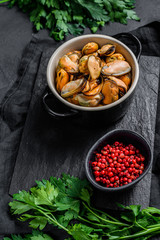 Cooked mussel meat on a cutting Board with parsley. Healthy seafood. Dark background. Space for text.