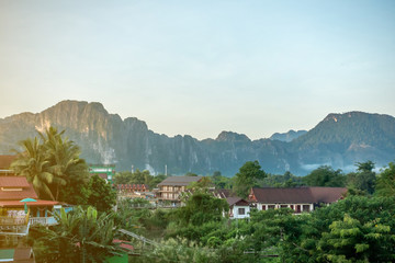 The view at the town called Vang Vieng in Laos with hotels or cottages with the limestone mountain and green forest in the good day. 