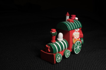 Fototapeta na wymiar Red children`s Christmas train on a black background. New Year's toy.
